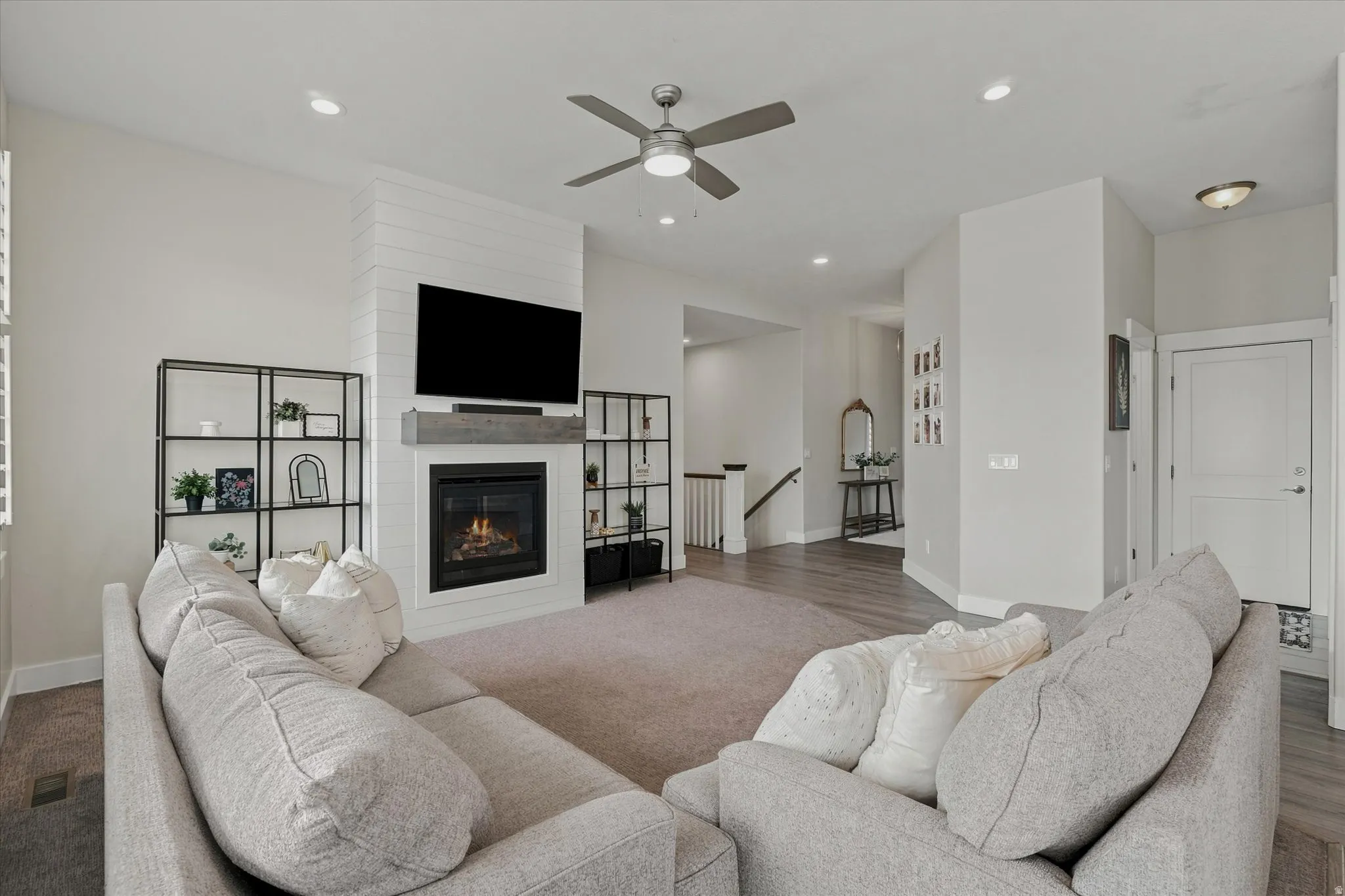 Living area featuring a floor-to-ceiling fireplace with shiplap detailing and a wood-finish mantel