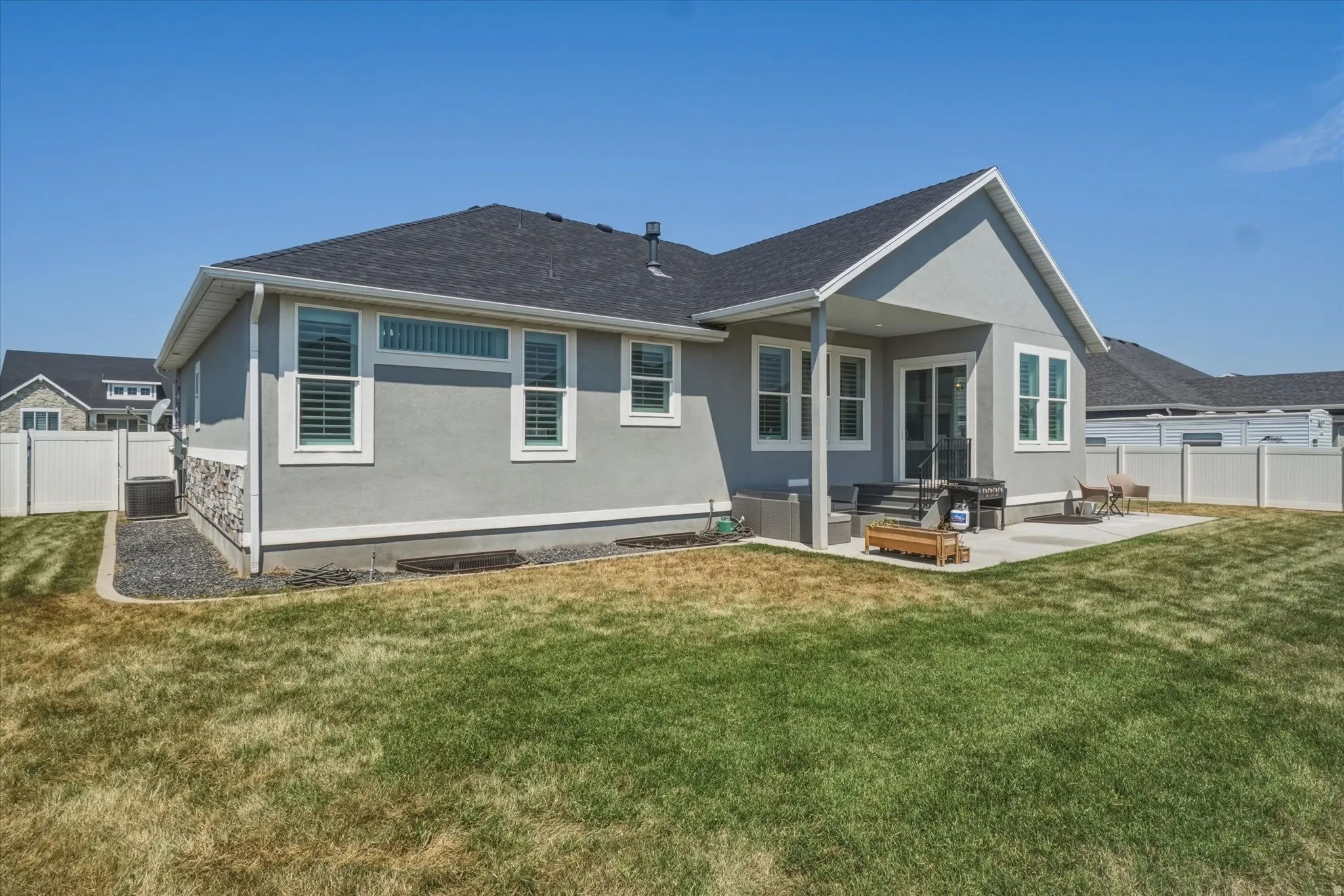 Rear exterior featuring a covered patio, concrete patio, and a privacy fence