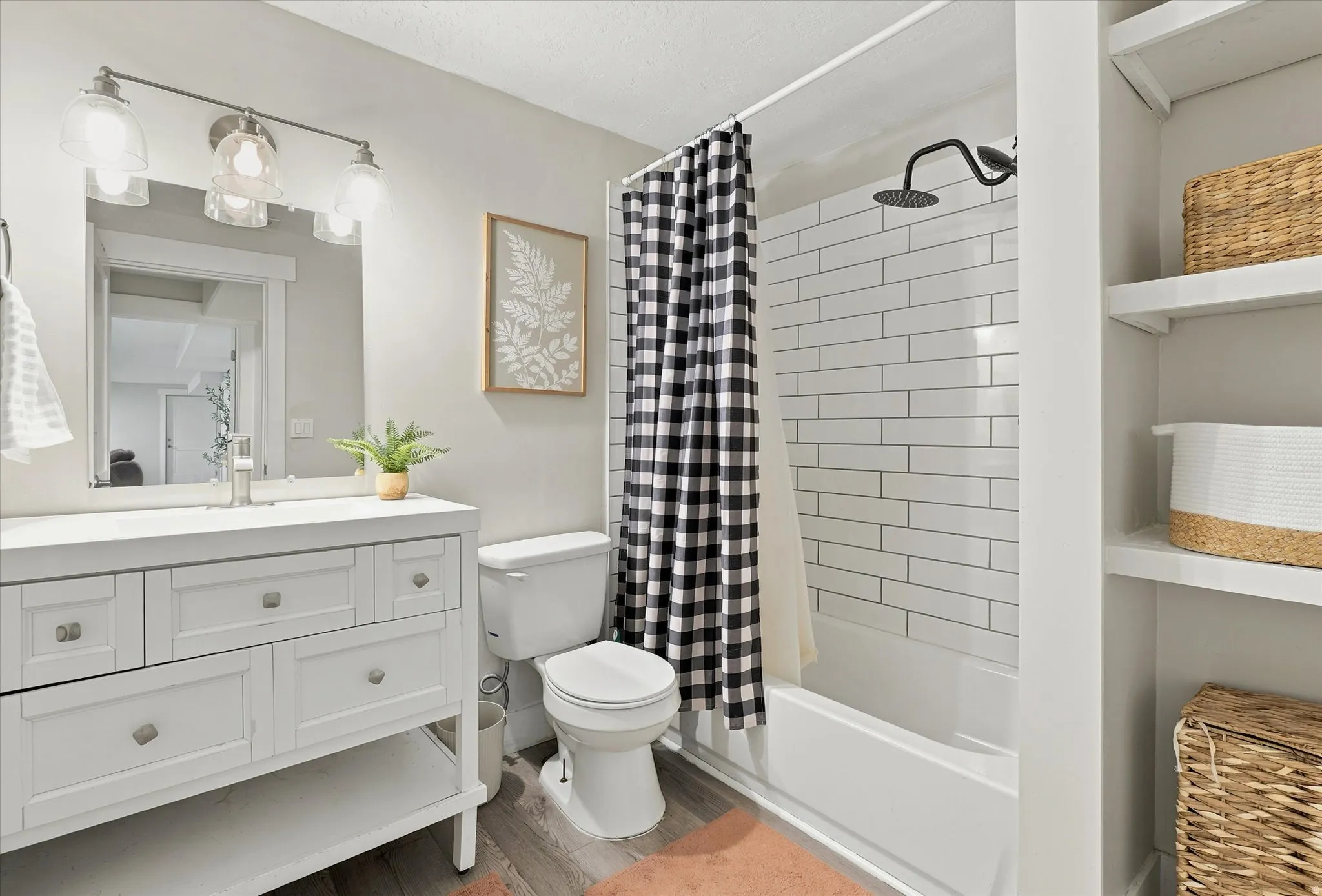 Bathroom featuring a white vanity with brushed nickel hardware, an integrated sink, and a framed mirror