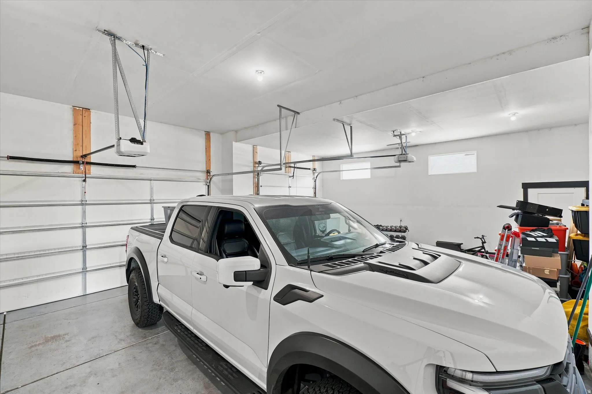 Spacious garage featuring a concrete floor, multiple automatic garage door openers, and recessed lighting