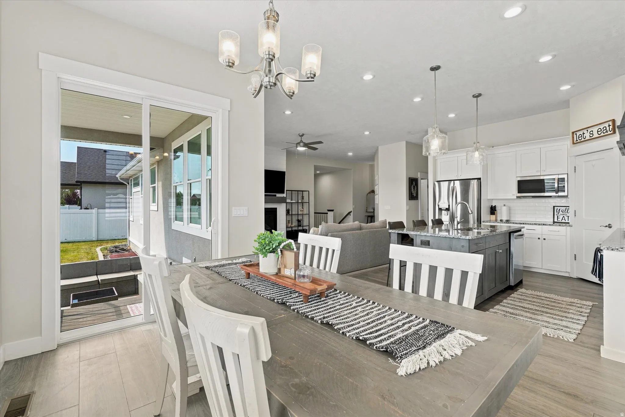 Dining area with wood-finish flooring and a contemporary chandelier