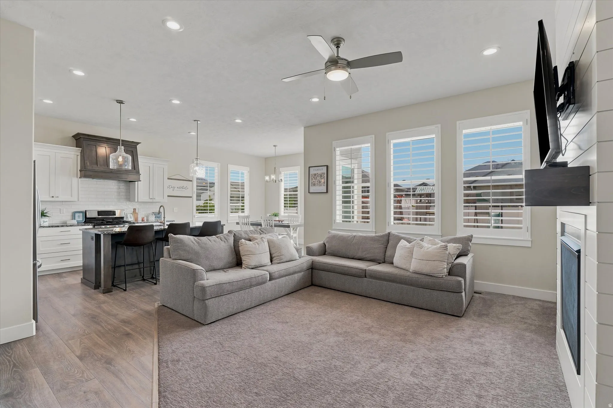 Open-concept living space featuring a living room with carpet flooring, recessed lighting, and a ceiling fan