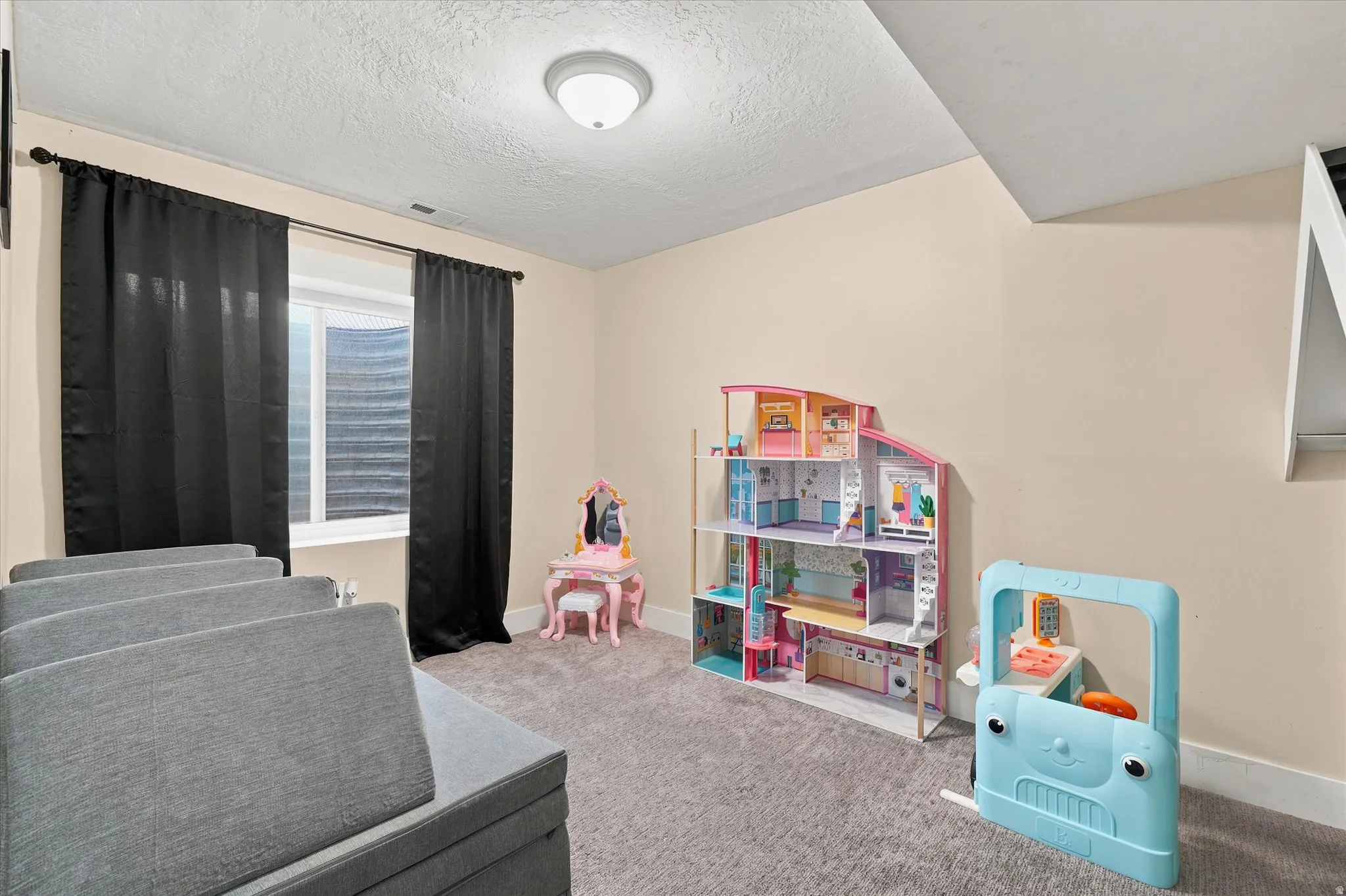 Carpeted room featuring a window with blinds, a flush mount ceiling light fixture, and neutral wall paint