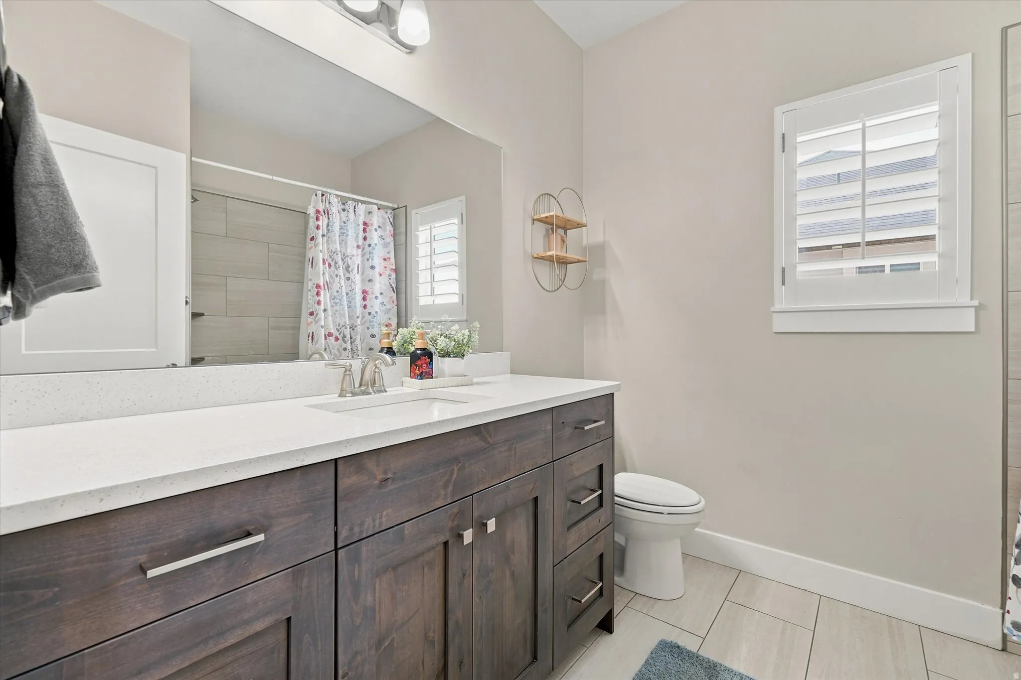 Contemporary bathroom featuring a dark wood-finish vanity with a white countertop and undermount sink