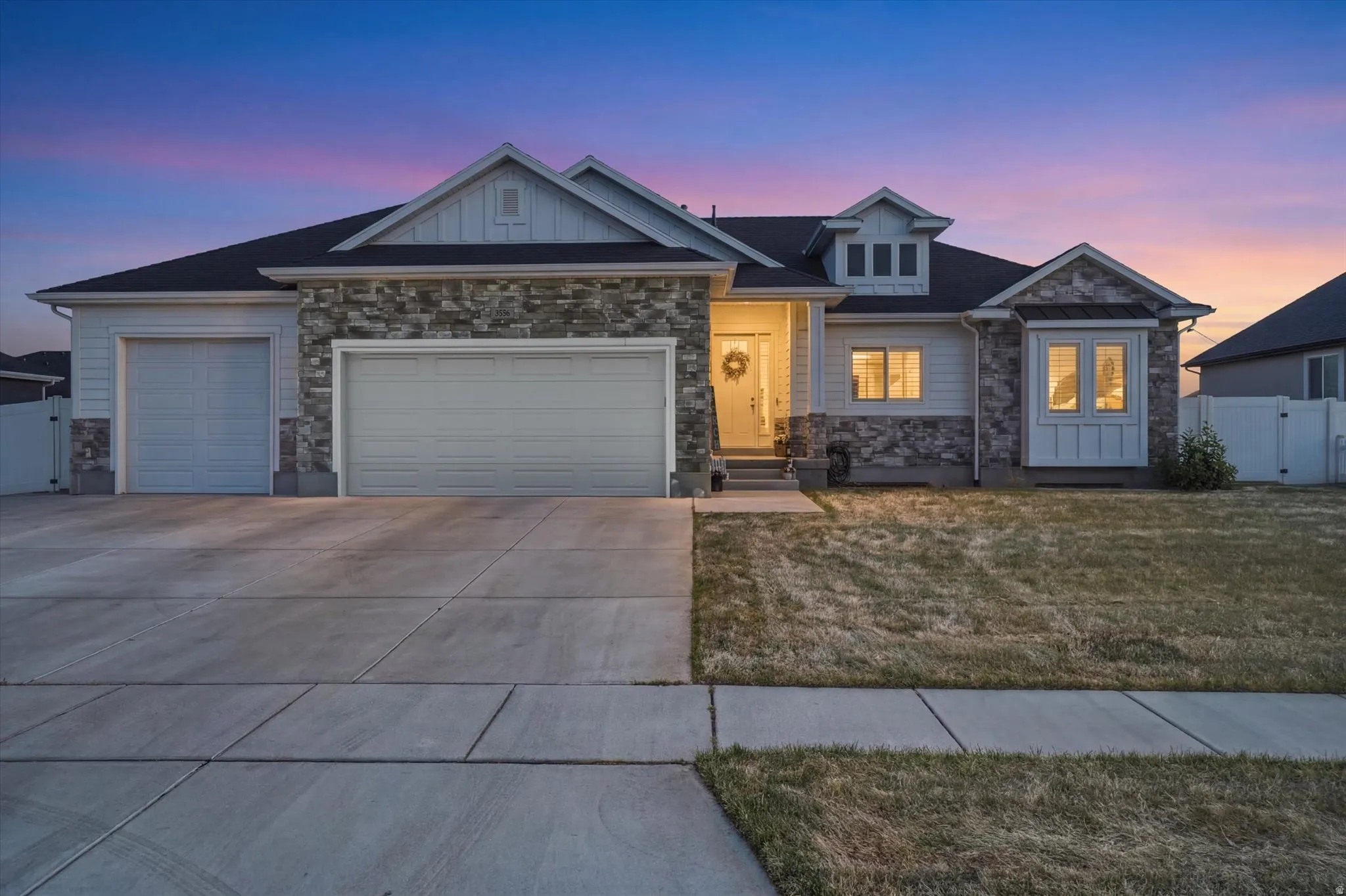 Contemporary exterior featuring varied siding materials including light-colored horizontal siding and stacked stone accents