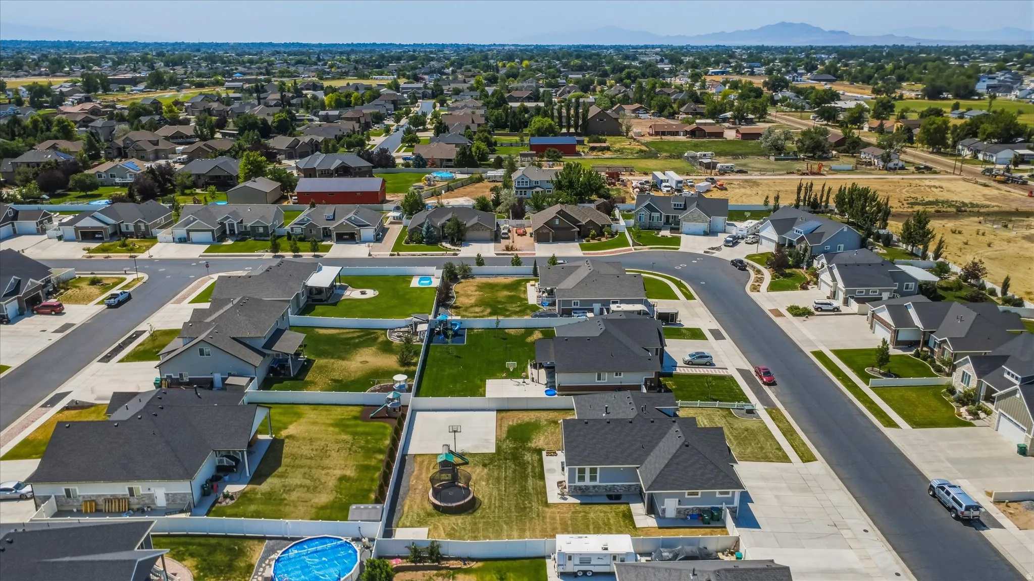 Aerial view of a residential neighborhood with detached homes, featuring paved streets and established landscaping