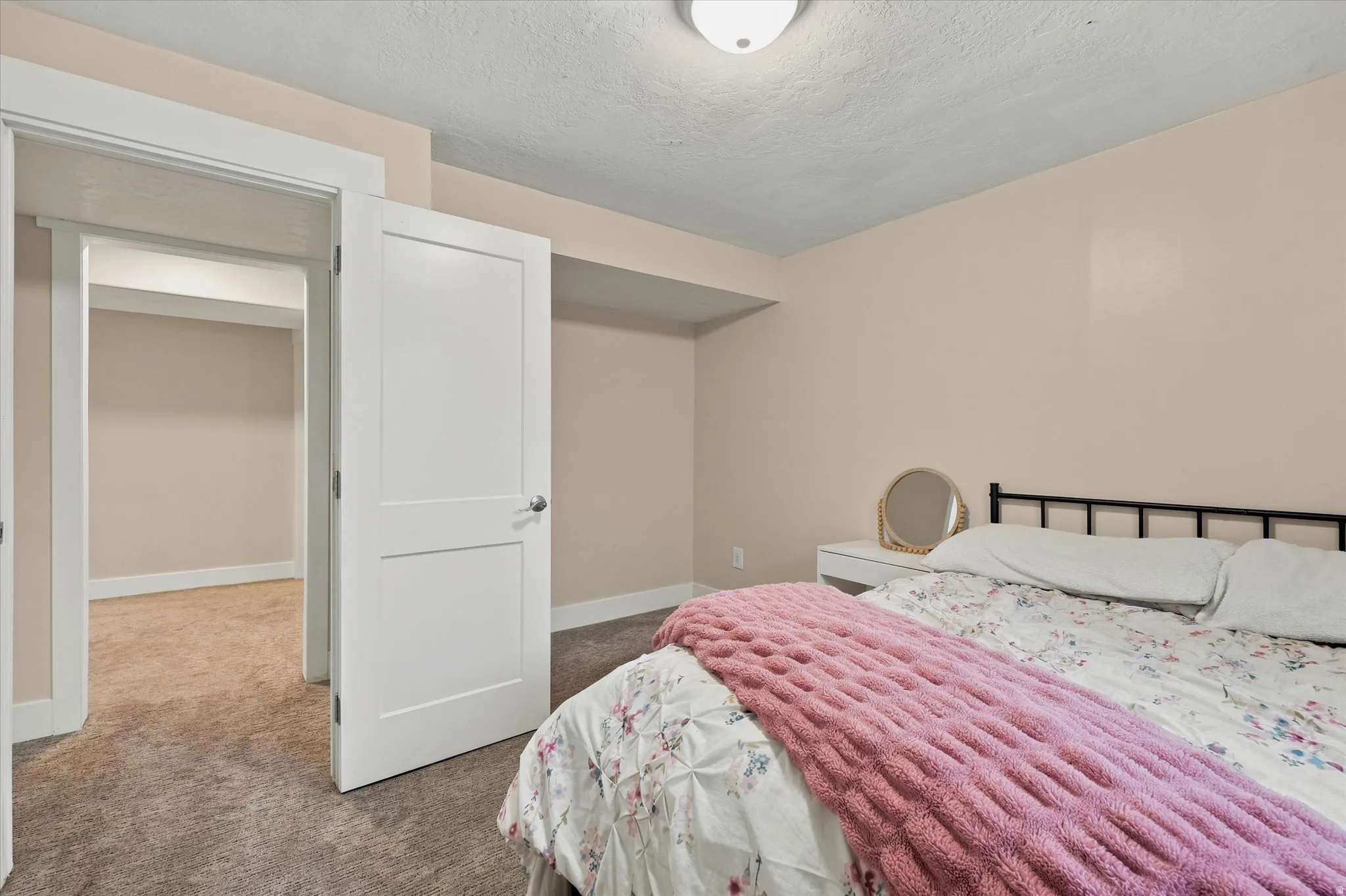 Bedroom featuring neutral tone walls, dark carpet flooring, and white trim