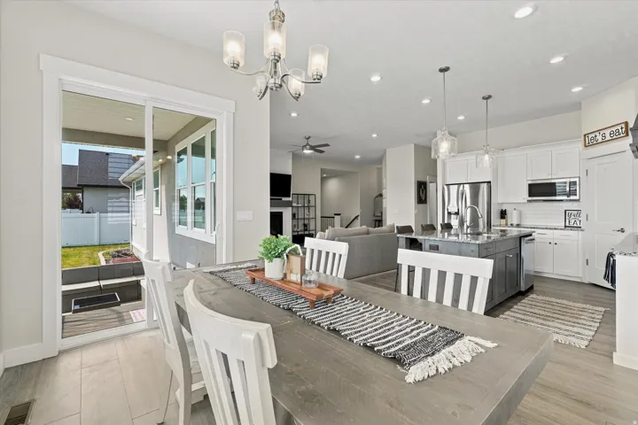 Dining area with wood-finish flooring and a contemporary chandelier