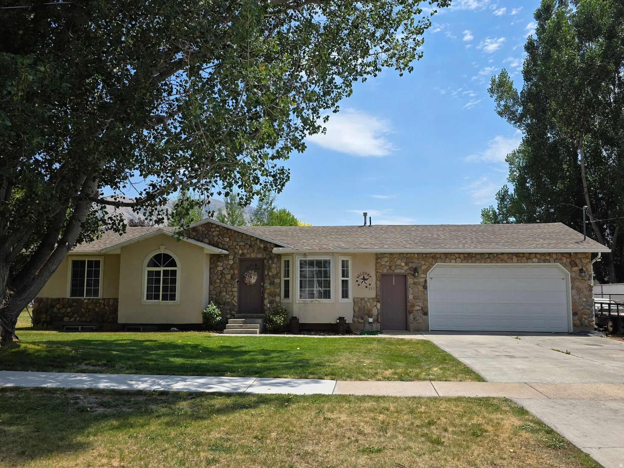 Ranch-style exterior featuring stone veneer and stucco siding