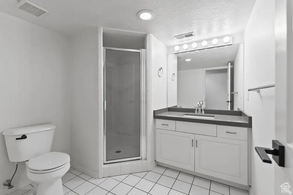 Bathroom featuring a vanity with a dark countertop, an integrated sink, and white cabinetry