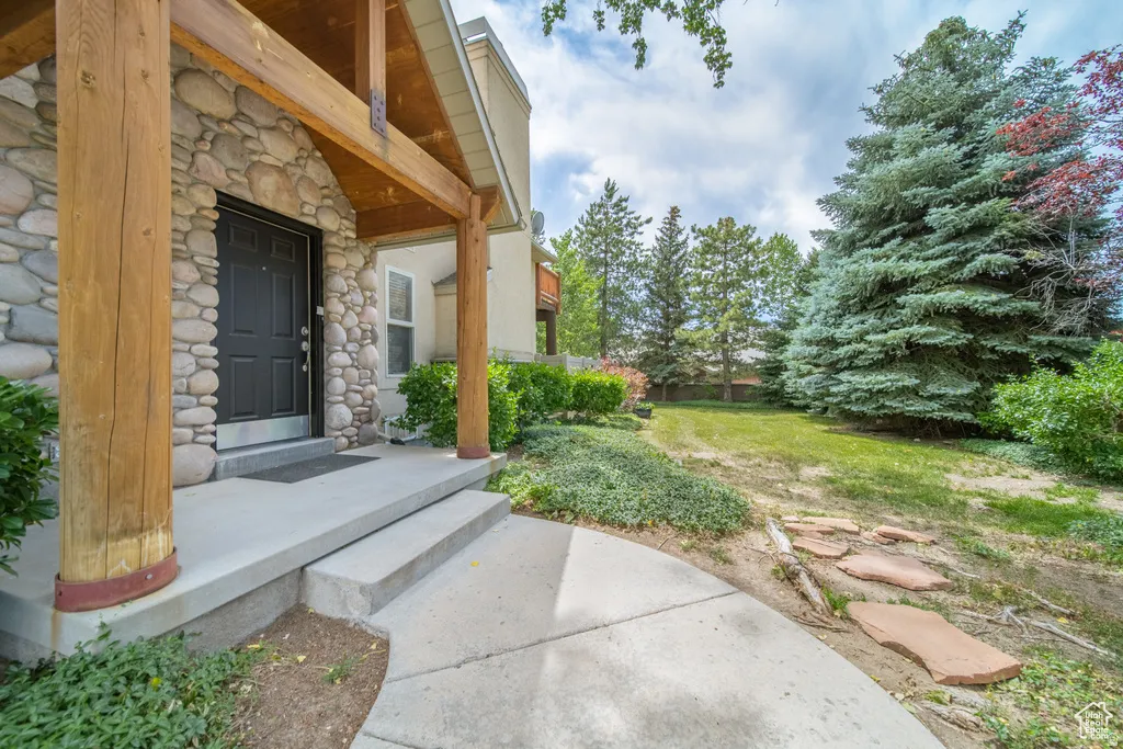 Stone facade entry with robust wood columns and a dark paneled door
