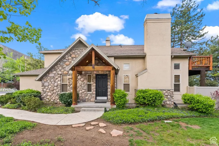 Stone and stucco exterior with an inviting covered entry