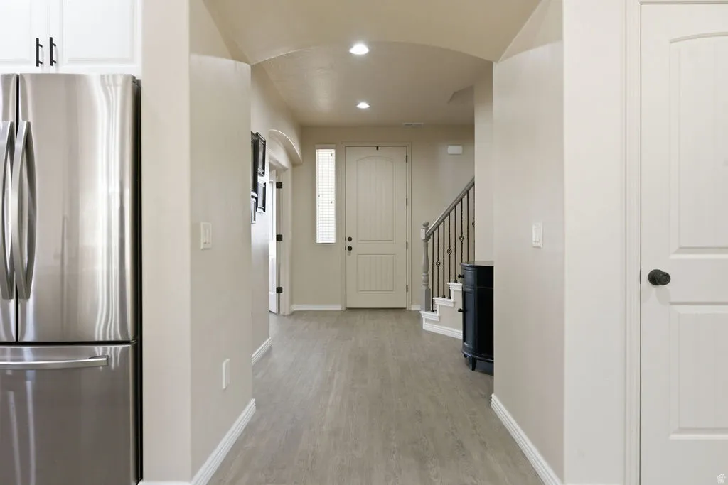 Bright entryway featuring light wood-finish flooring, recessed lighting, and a neutral color palette