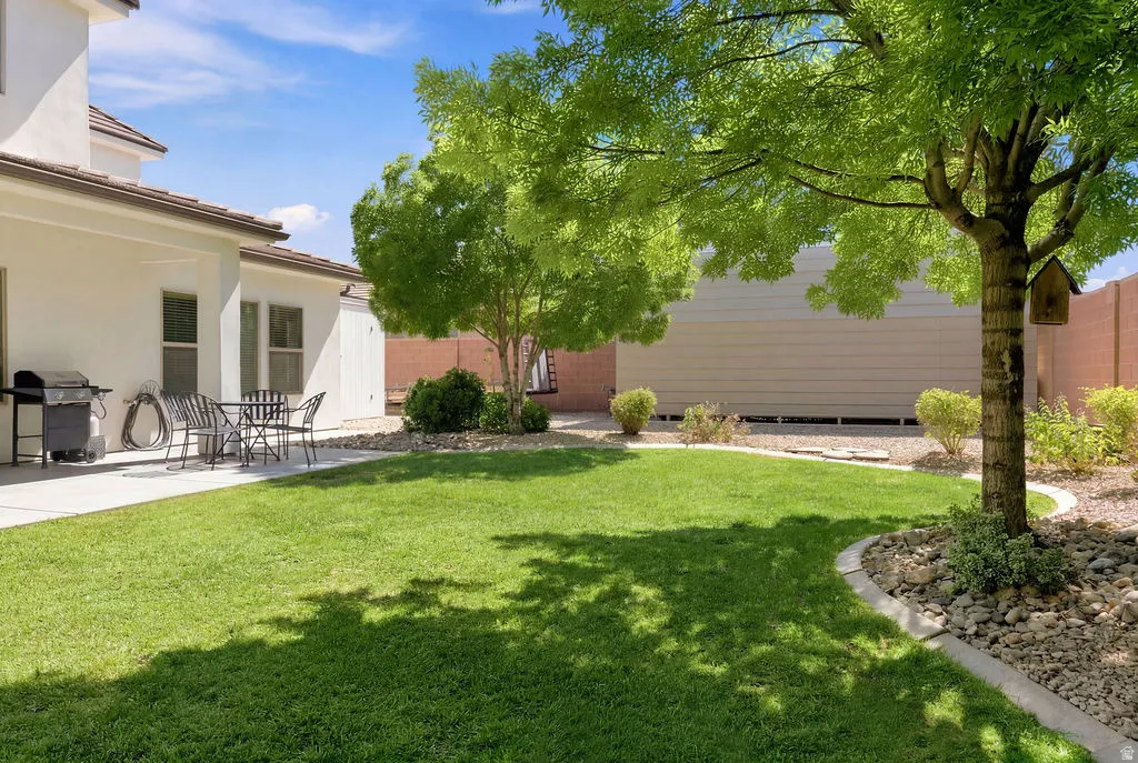 Expansive green lawn with mature trees providing natural shading