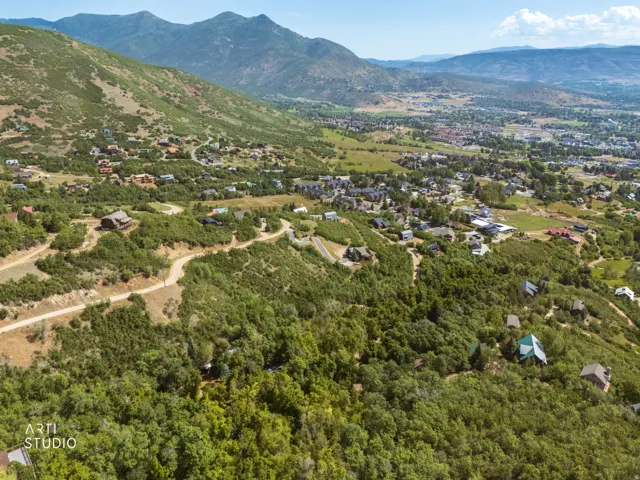 Expansive mountain landscape featuring varied terrain and distant residential development