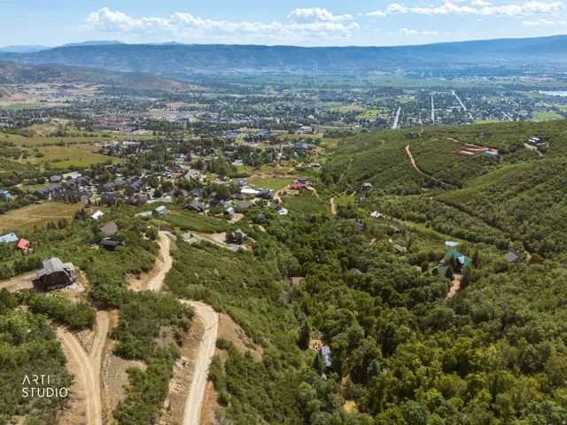 Expansive aerial perspective showcasing a mountainous terrain with dense green foliage