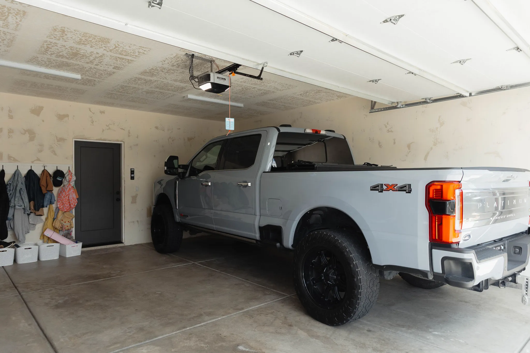 Spacious two-car garage featuring a concrete floor, automatic door opener, and interior access door