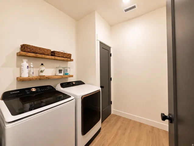 Utility area featuring wood-finish flooring and two floating wood shelves