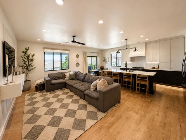 Open concept living area with wood-finish flooring, recessed lighting, and a contemporary ceiling fan