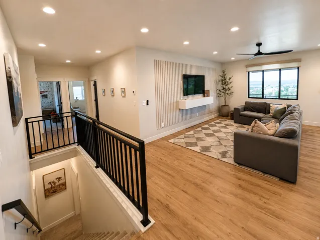 Spacious room with wood-finish flooring, recessed lighting, and a contemporary ceiling fan