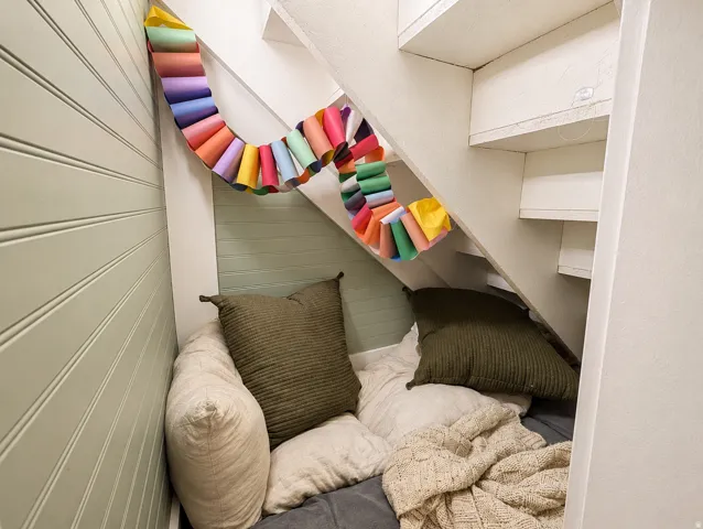 Under-stair alcove featuring beadboard wall paneling and a painted finish
