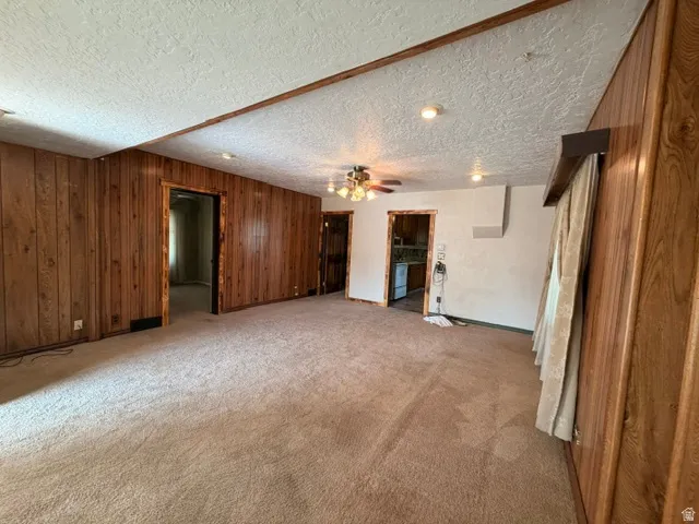 Spacious interior featuring wood paneling, textured ceilings, and recessed lighting