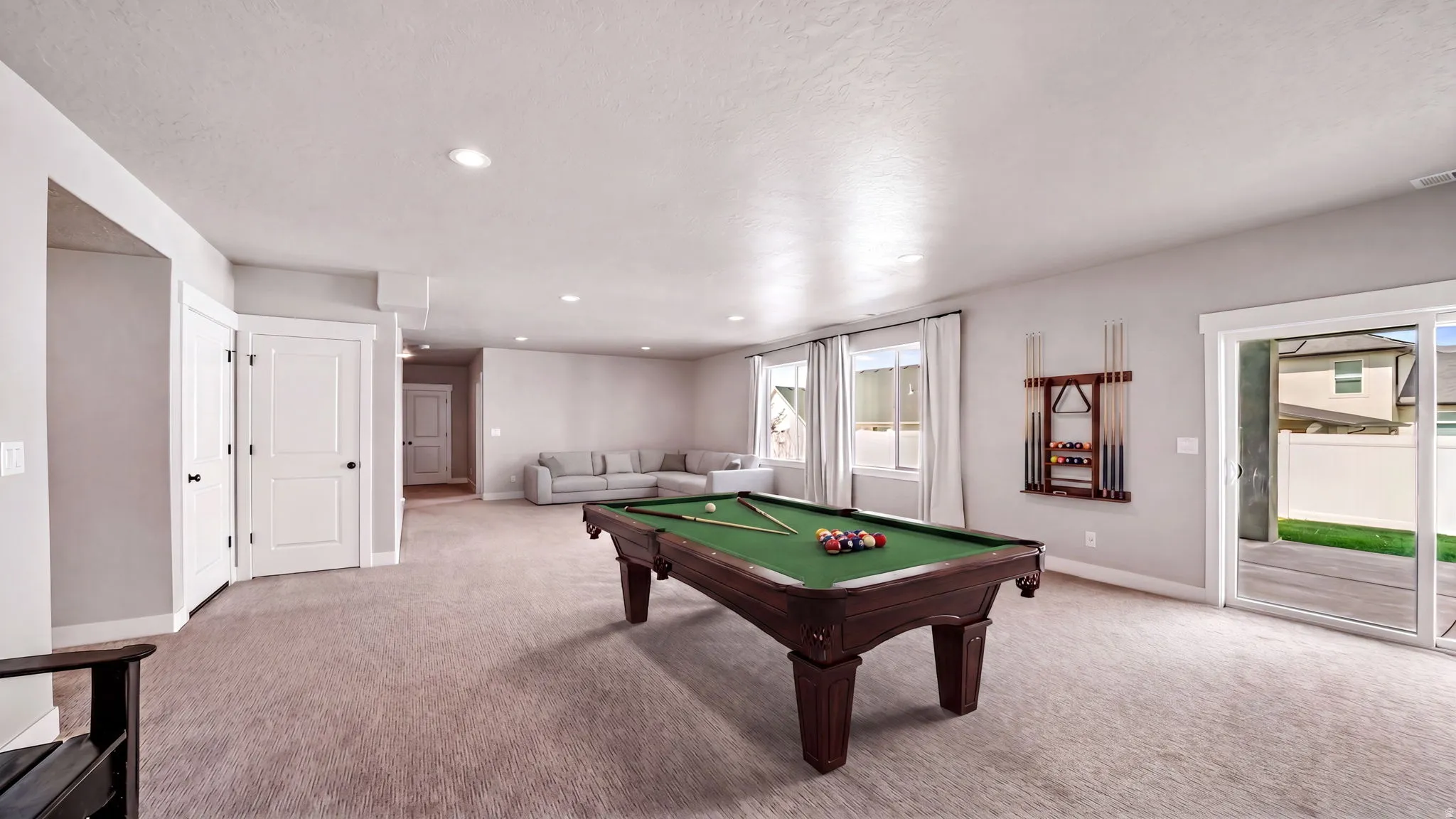 Spacious recreational area featuring recessed lighting and neutral-toned carpeting