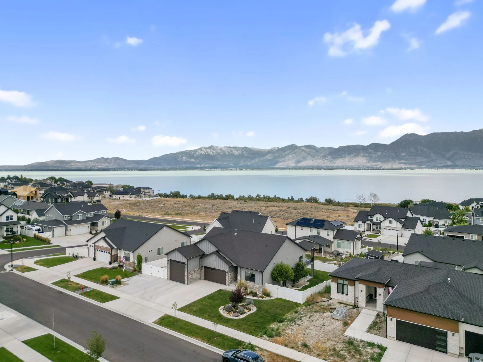 Residential neighborhood featuring contemporary homes with dark shingle roofs and landscaped front yards