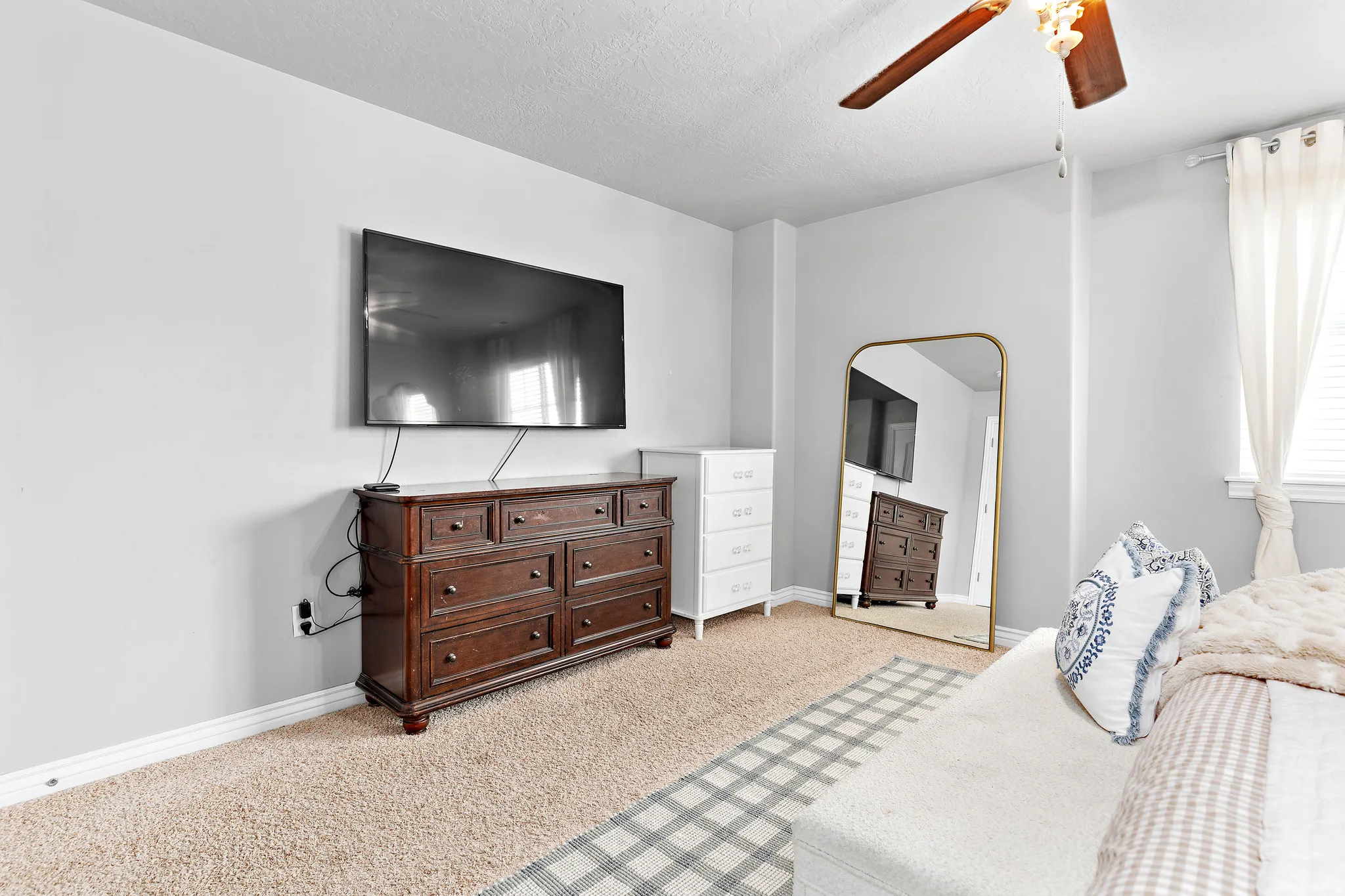 Carpeted room featuring a ceiling fan with integrated lighting, window with blinds and drapes, and light gray wall paint