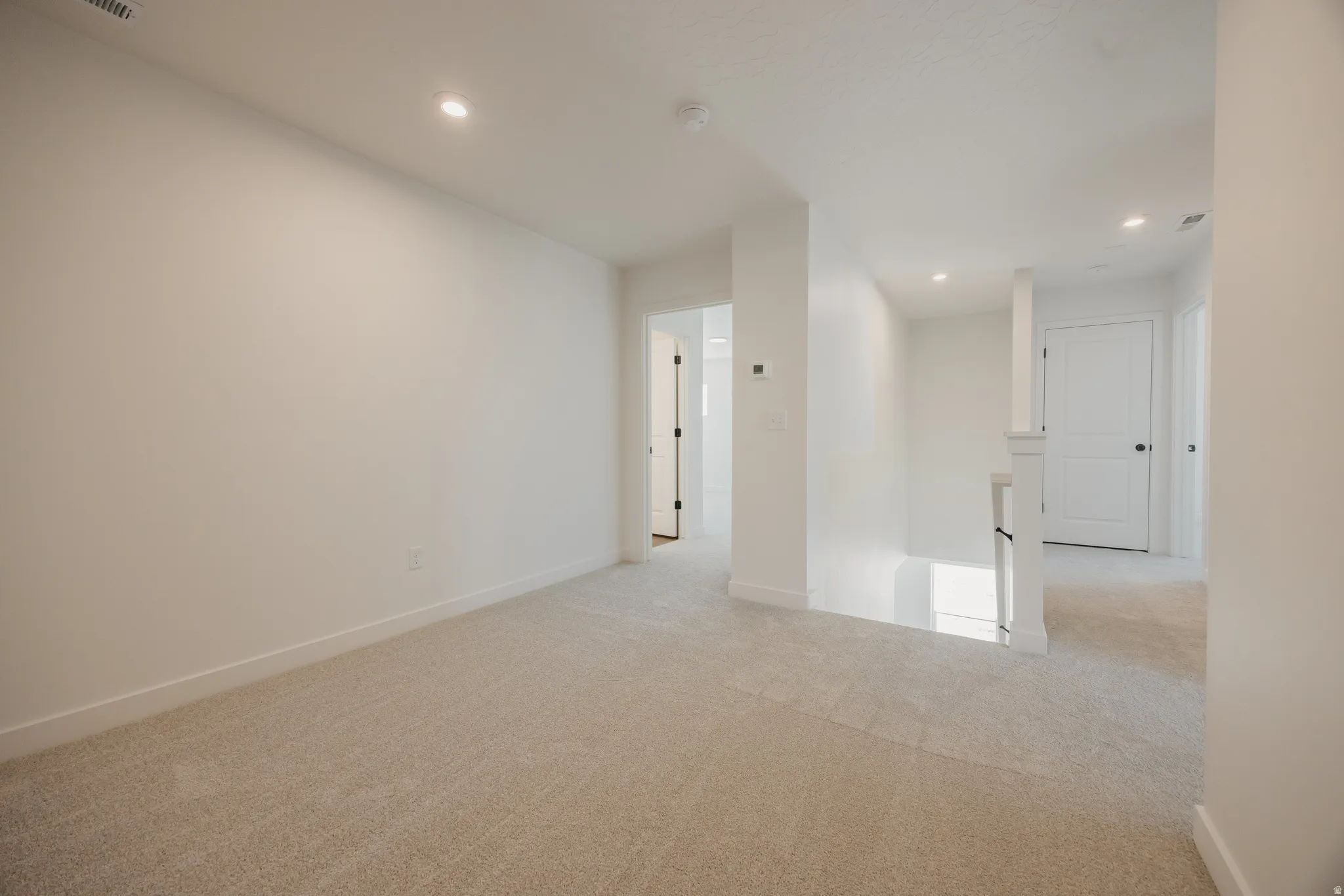 Carpeted room featuring recessed lighting, white walls, and white baseboards
