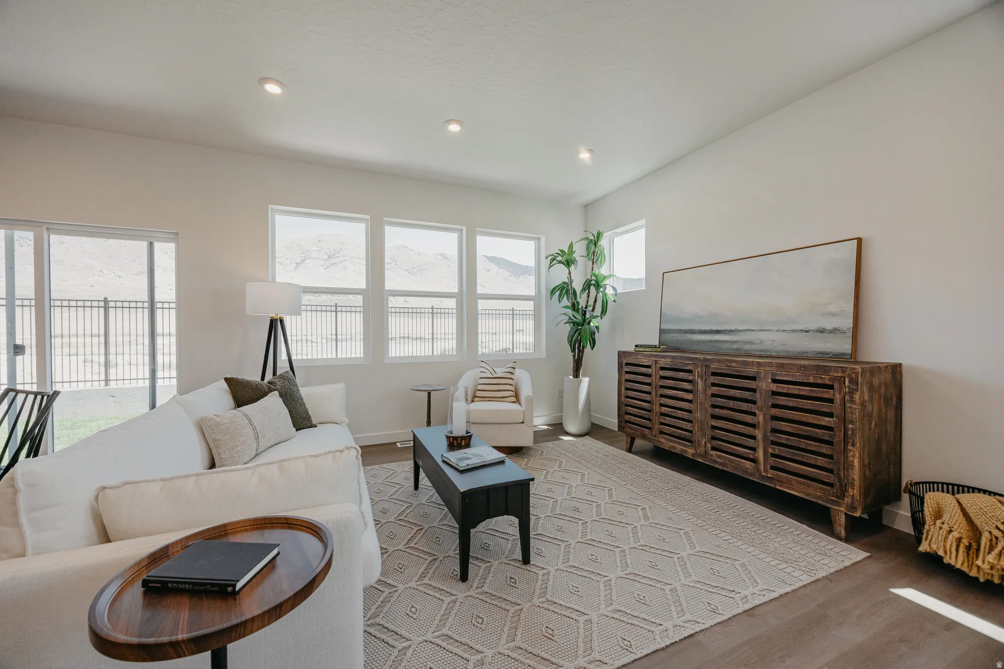 Recessed ceiling lighting, wood-finish flooring, sliding glass door, multiple windows, and light-toned walls