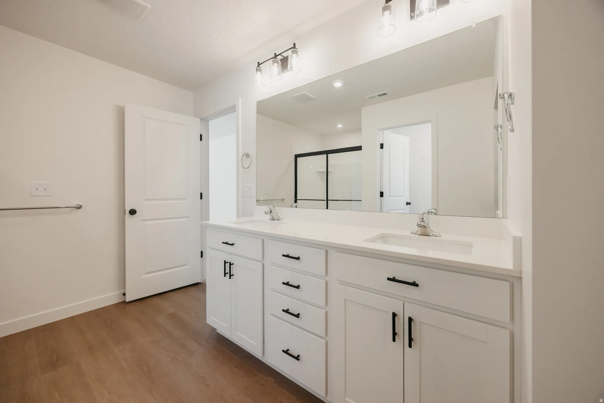 Dual-sink vanity with white cabinetry and black hardware