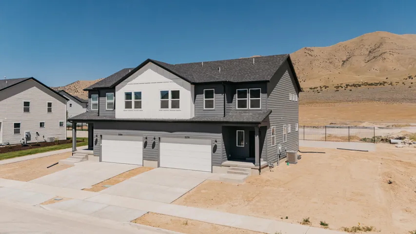 Modern duplex featuring grey siding, white trim, and a dark shingle roof