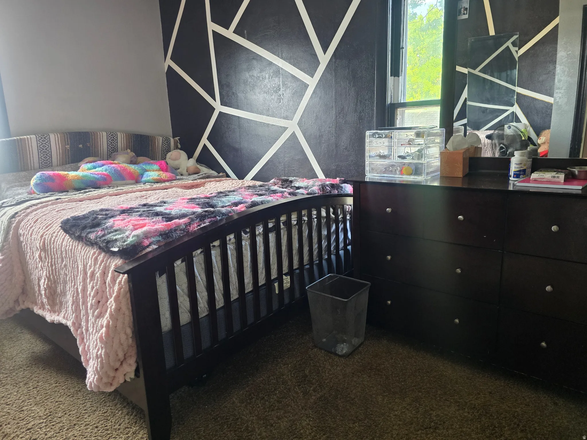 Bedroom with dark accent wall featuring a geometric pattern