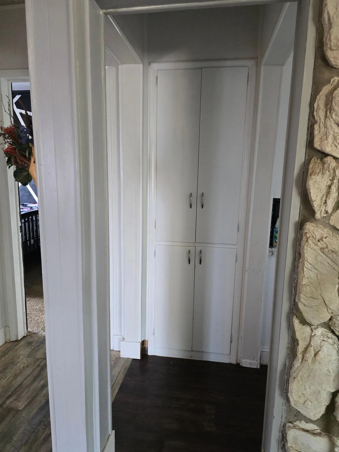 Built-in hallway cabinetry with painted white doors and silver hardware