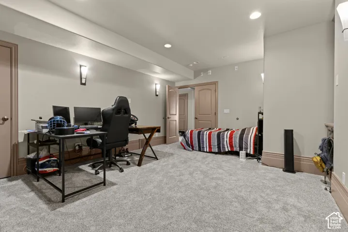 Spacious room featuring light-colored walls, recessed lighting, and wall-mounted sconces