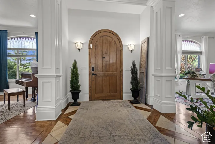 Arched solid wood entry door flanked by wall sconces