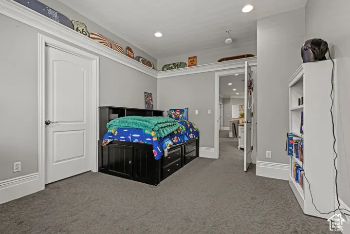 Carpeted room with recessed lighting, crown molding, and white trim