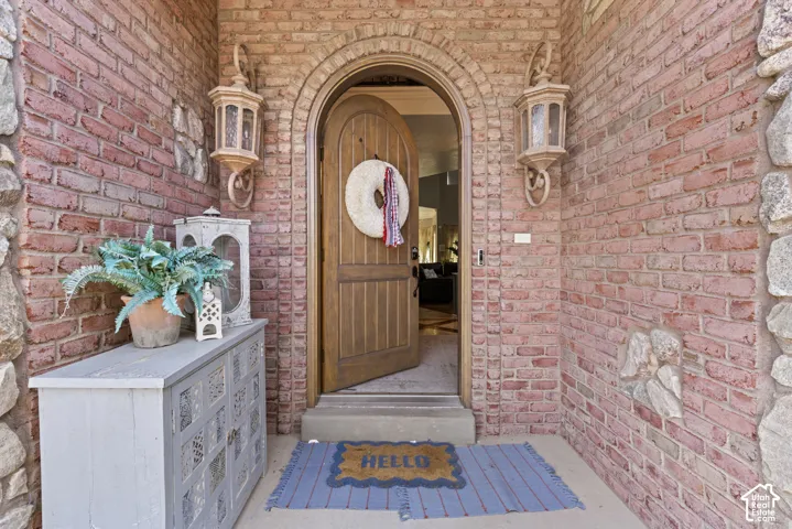Arched entryway with a solid wood door, flanked by brickwork and stone accents