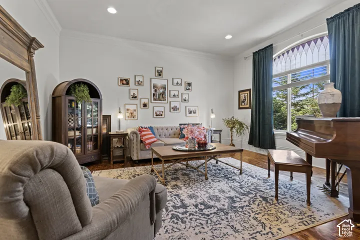 Spacious living area featuring high ceilings, crown molding, recessed lighting, and wood-finish flooring