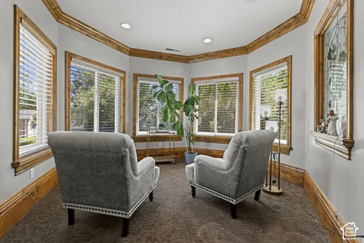 Bay window alcove featuring extensive wood trim, recessed lighting, and patterned carpet flooring