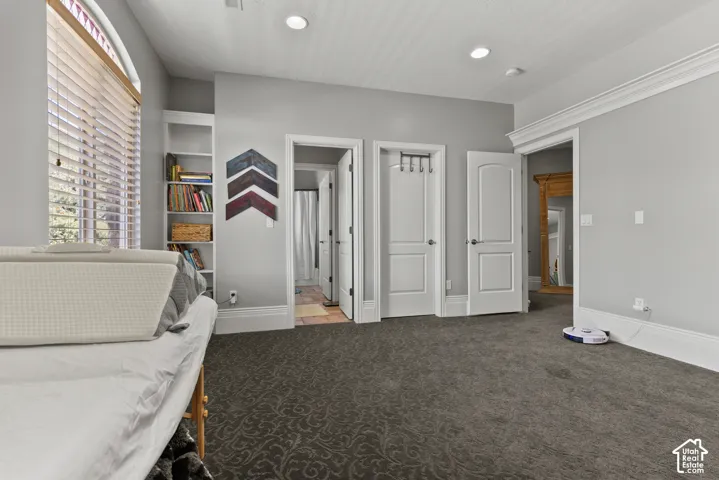 Interior space featuring patterned carpeting, recessed lighting, crown molding, and baseboards