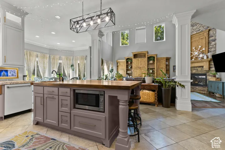 Spacious kitchen featuring a large island with wood-finish countertop, under-counter microwave, and ample cabinetry