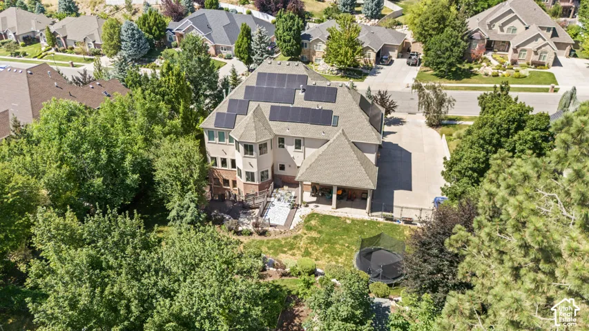 Multi-level residence featuring a prominent turret, solar panels, and a covered patio