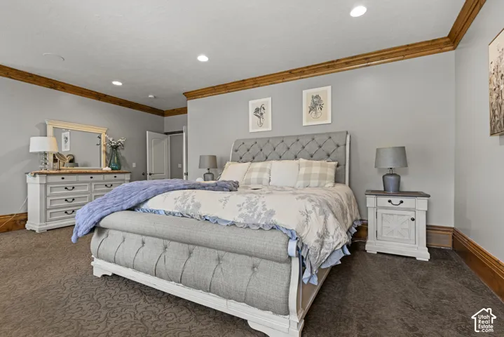 Recessed lighting illuminates the room, featuring wood-finish crown molding and baseboards