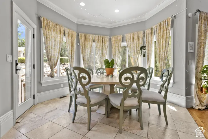Bay window dining area featuring neutral tile flooring, light gray walls, white trim, and a glass-paneled exterior door