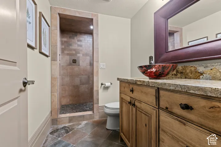 Walk-in shower with natural stone tile and pebble floor