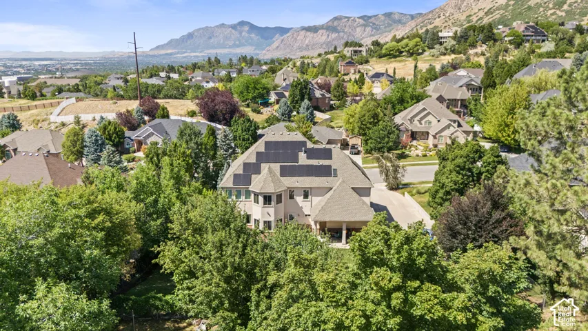 Multi-story residence featuring extensive solar paneling, a covered entry, and a prominent bay window