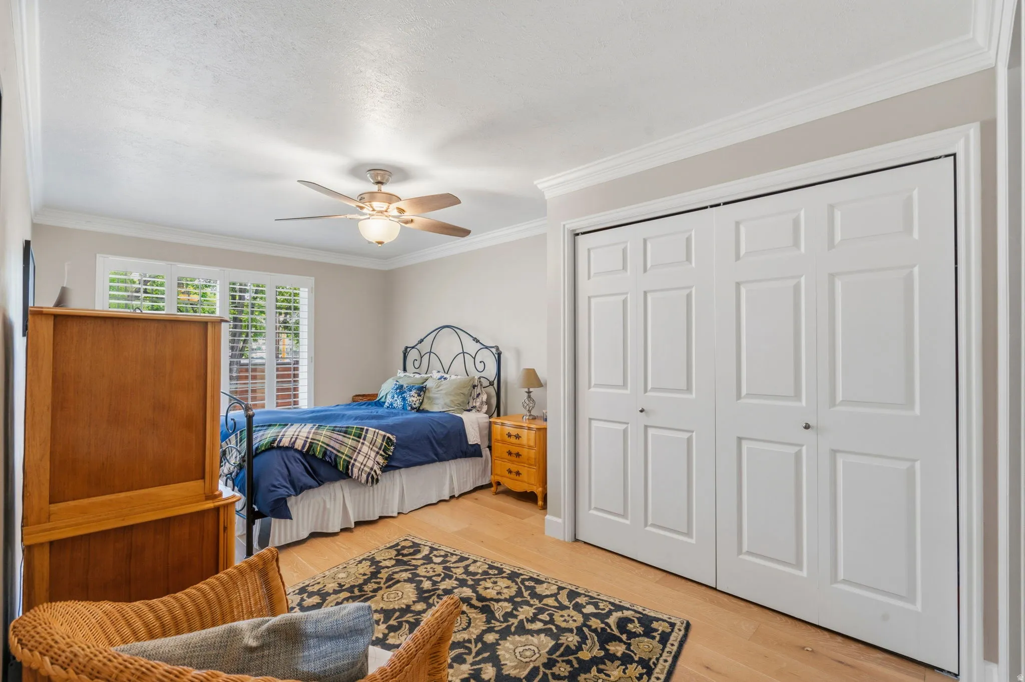 White oak flooring complements the room's two-tone paint with lots of natural light, ceiling fan, plantation shutters, crown molding and private full bath.
