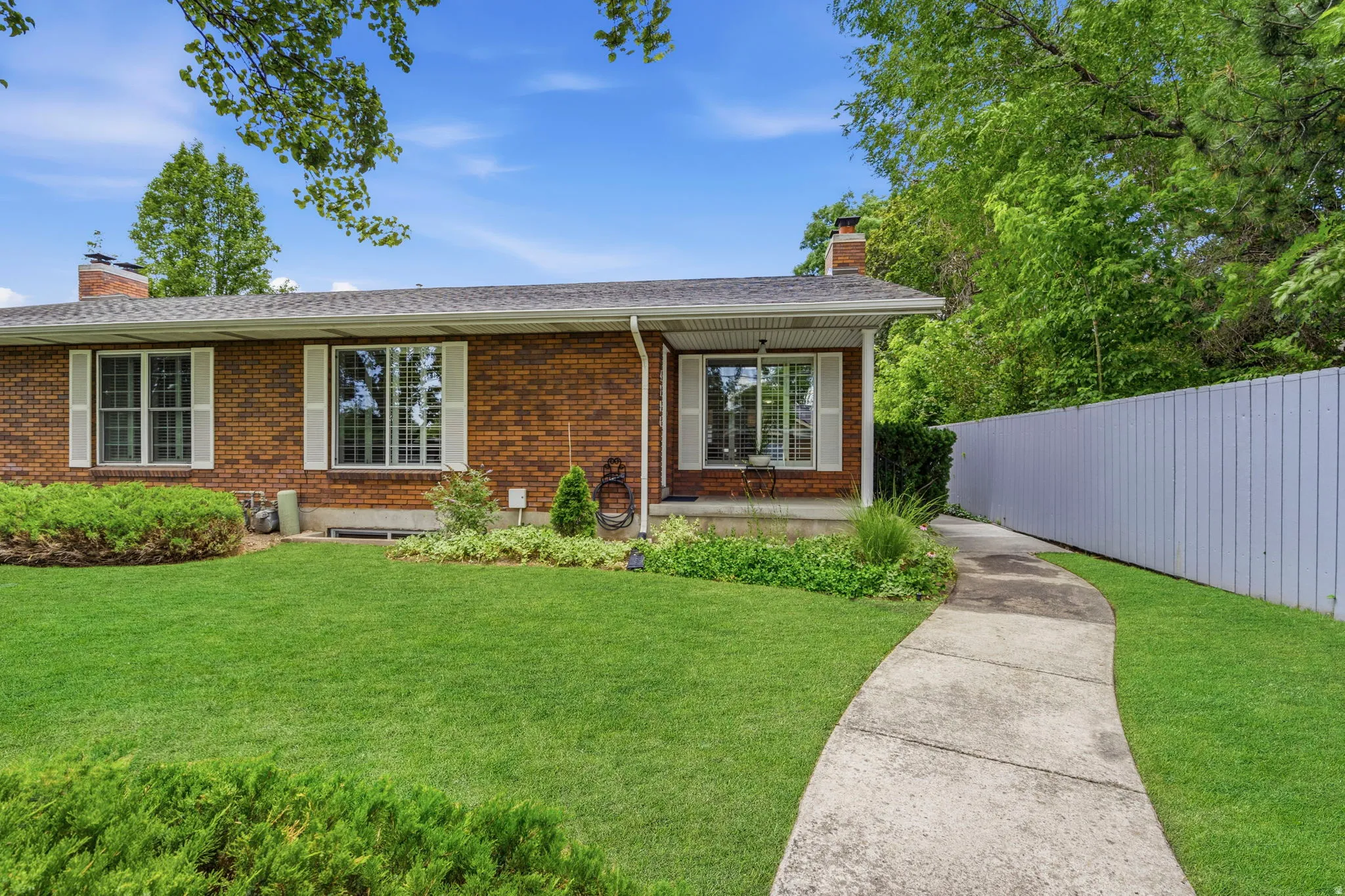 Brick exterior with shutters and covered front porch, duplex building.